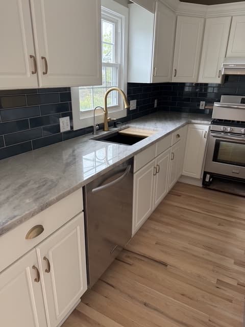 White and navy kitchen with tile backsplash by Benco Remodeling